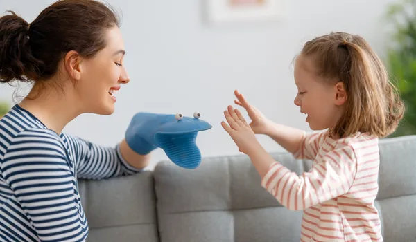 Técnicas lúdicas para la atención del TDAH, una mamá y una niña en un sillón, la mamá usa una marioneta en la mano